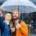 Hipster couple under umbrella in rainy spring cold weather