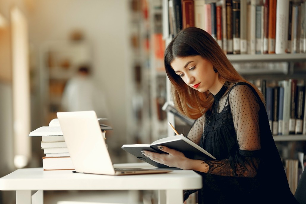 Studentin liest in Bibliothek