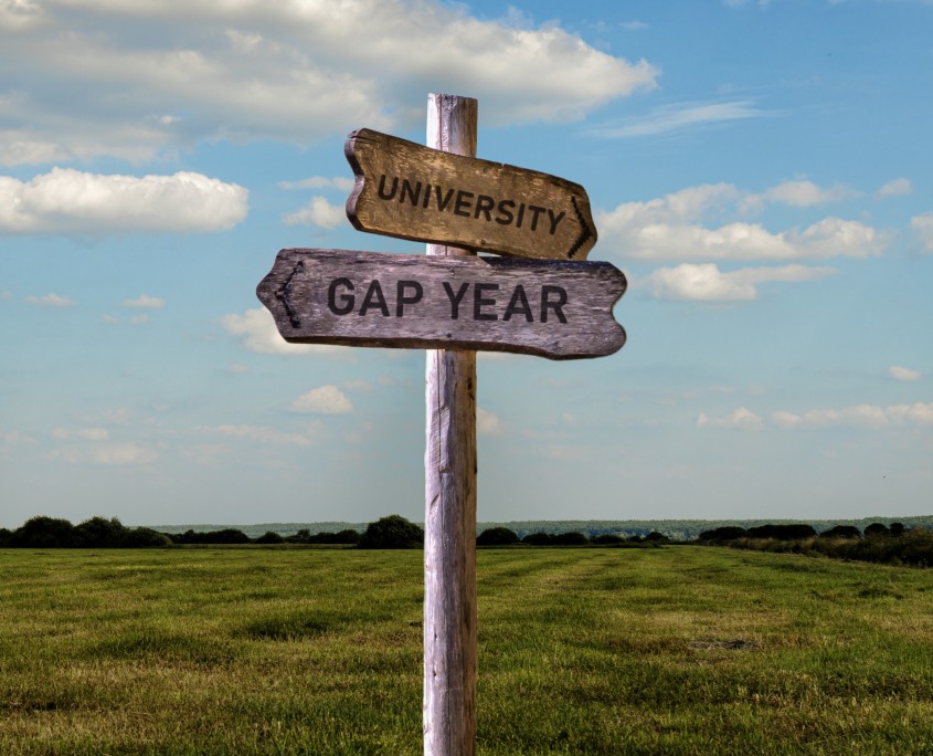 Schild mit Gap Year oder Universität Pfeile die in verschiedene Richtungen zeigen - finde deinen Weg nach dem Studium