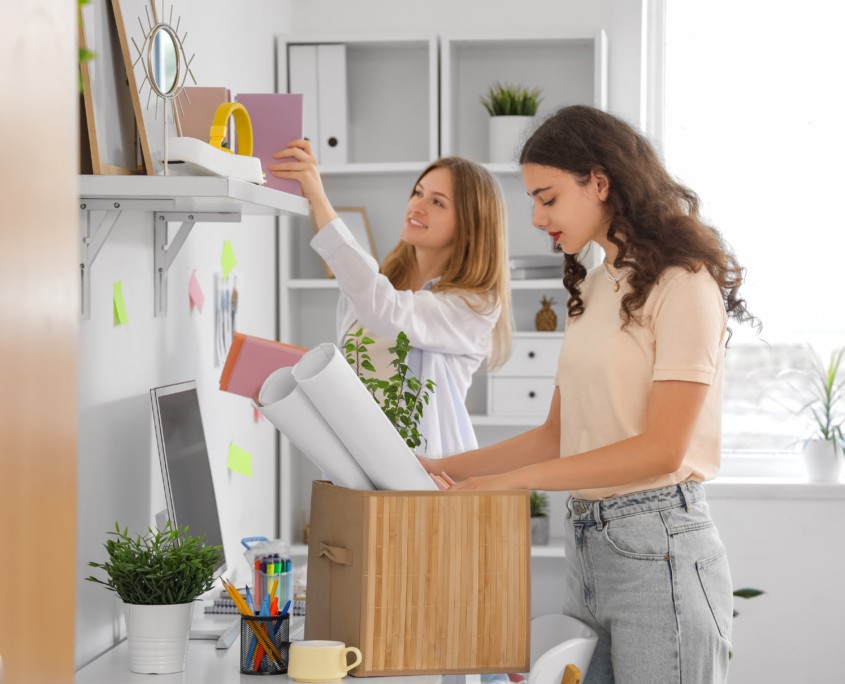 Female students unpacking things in dorm room on moving day